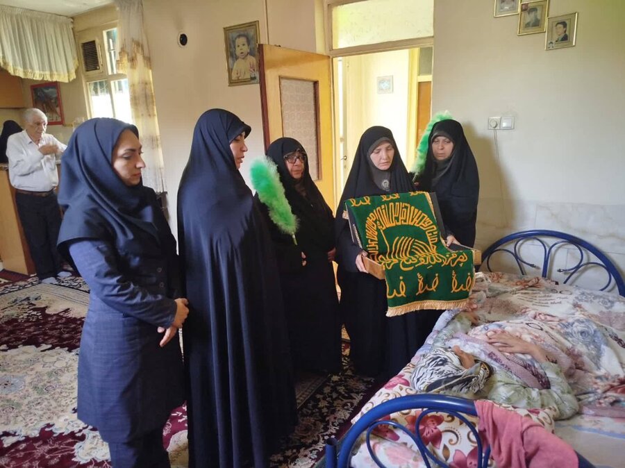 شهر قدس | آیین پرچم گردانی حرم مطهر رضوی در منزل دو مددجوی بسترگرا برگزار شد