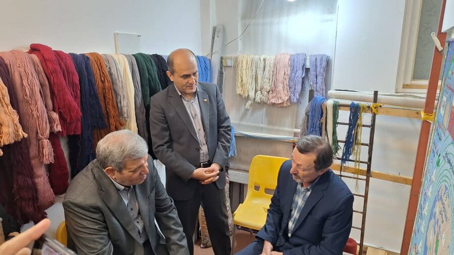 رییس سازمان بهزیستی کشور کنار دار قالی هنرمند ناشنوا نشست